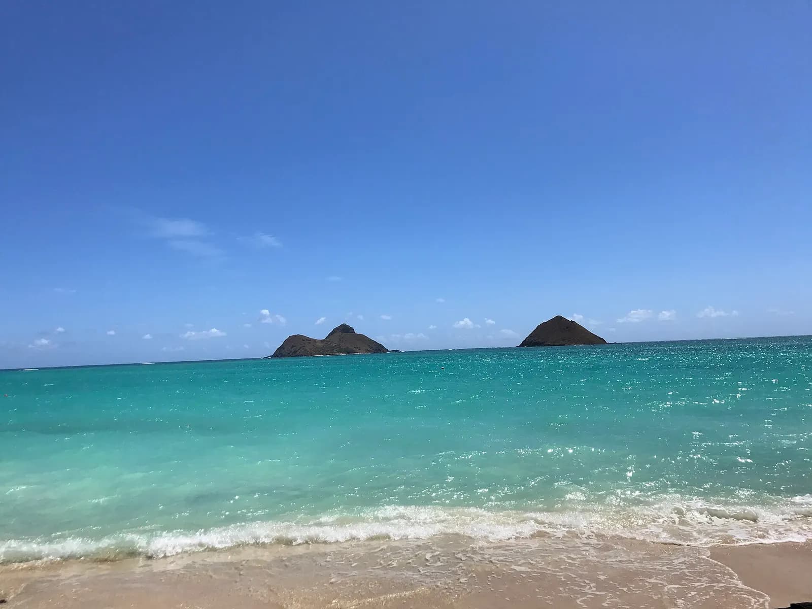 Hai hòn đảo Mokulua nổi lên từ mặt biển xanh ở Lanikai